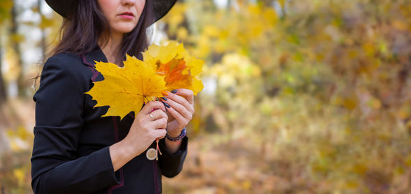 Young woman holding yellow flower