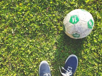 Low section of man by soccer ball on field