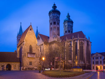 Illuminated building against blue sky at dusk