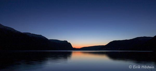 Scenic view of lake against clear sky during sunset