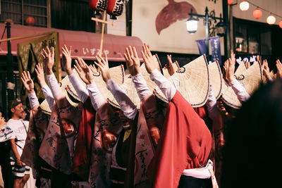 Women dancing with arms raised during awa dance festival