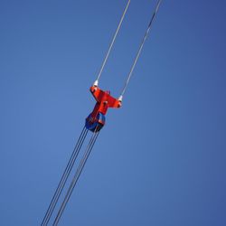 Low angle view of crane against clear blue sky