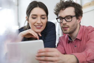 Man and woman looking at tablet in office