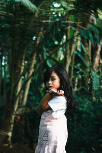 Full length of woman standing by tree