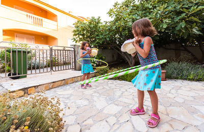 Full length of girls playing hula hoop