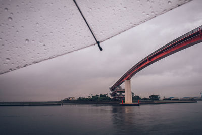Bridge over river against sky in city