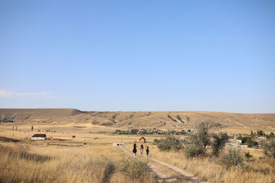 People on field against clear sky