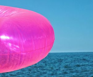 Close-up of pink balloon against blue sky