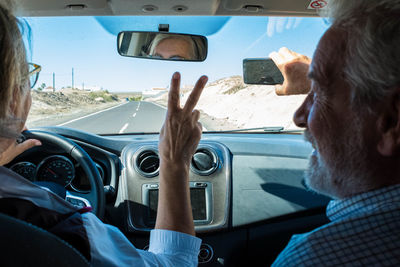 Man taking selfie with woman driving car