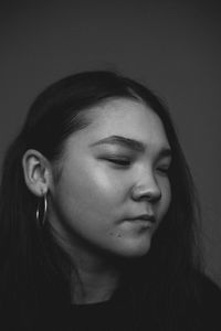 Close-up portrait of a beautiful young woman over black background