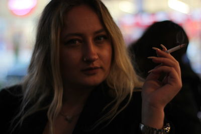 Portrait of young woman smoking cigarette