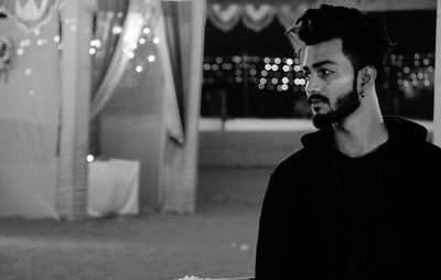 Portrait of young man looking away at night