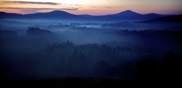 Scenic view of mountains against cloudy sky