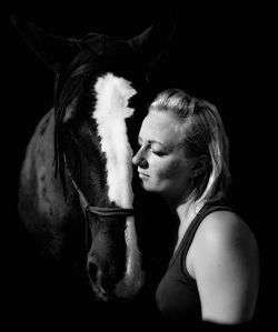 Woman looking at camera against black background