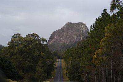 Road by trees against sky