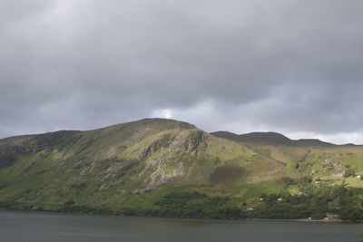 Scenic view of lake and mountains against cloudy sky