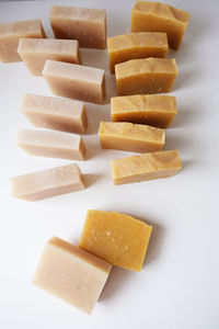 Close-up of chopped bread in plate against white background