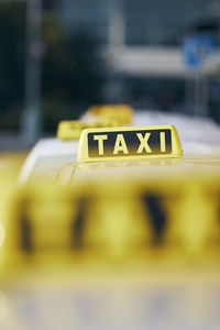 Selective focus on taxi sign on roof. car waiting for passenger in city street.