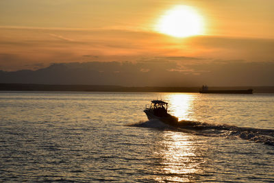 Silhouette boat on sea against sky during sunset