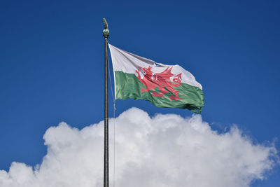 Low angle view of flag against blue sky