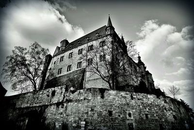 Low angle view of old building against cloudy sky