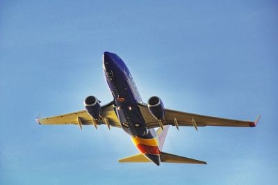 Low angle view of airplane flying against clear sky