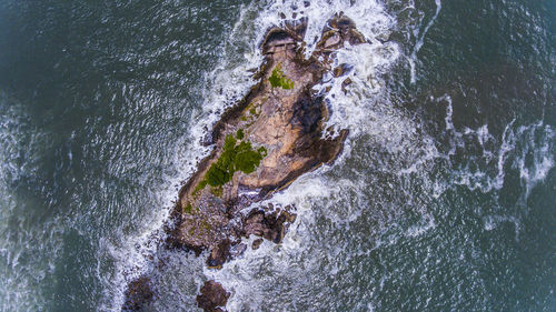 High angle view of waves splashing on rocks