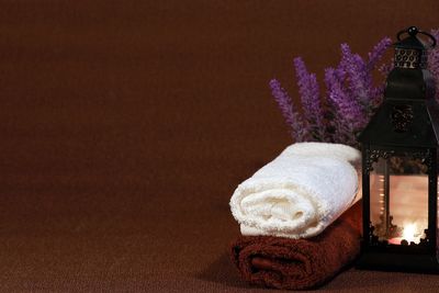 Close up of lit candle and towels on table