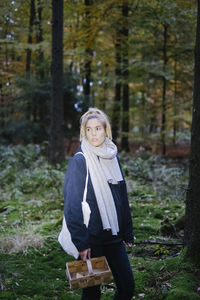 Beautiful woman looking away while standing in forest