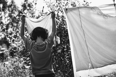 Low angle view of girl hanging sheets