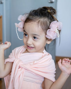 A little girl is standing in a beautiful dress with hair accessories. pretend play at home.