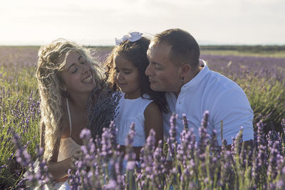 Portrait of smiling friends standing on field against sky