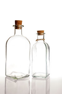 Close-up of empty glass bottle against white background