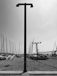 Sailboats moored at harbor against sky