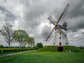 Traditional windmill on field against sky