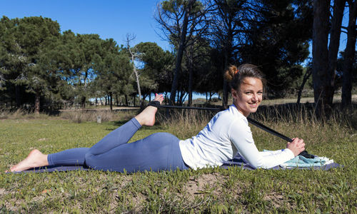 Young woman in nature doing exercises with rubber bands