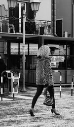 Full length of woman standing on railing