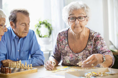 Senior people playing leisure games at table in nursing home