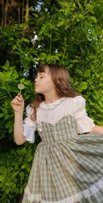 Woman looking away while holding plant