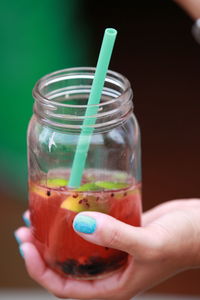 Close-up of hand holding glass of drink