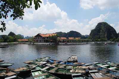 Scenic view of river by buildings against sky