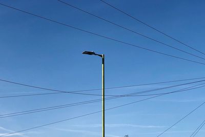 Low angle view of power lines against sky