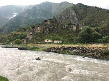 Scenic view of river by mountain against sky