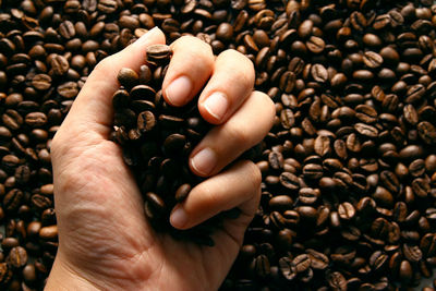Close-up of hand holding coffee beans