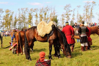 Horses on field against sky