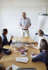 Senior businessman discussing with colleagues in board room