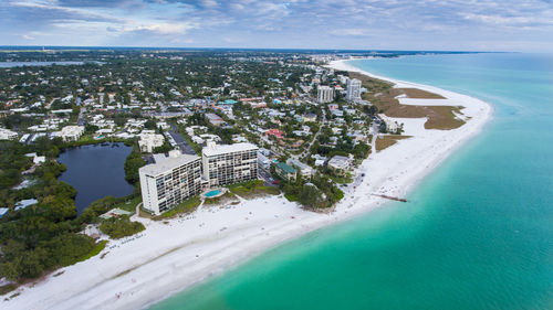 Aerial view of cityscape by sea against sky