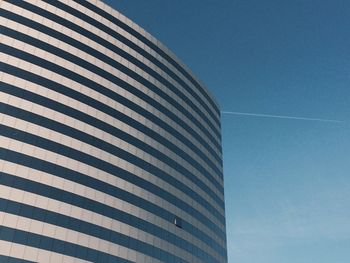 Low angle view of modern building against blue sky