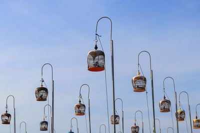 Low angle view of street lights against blue sky