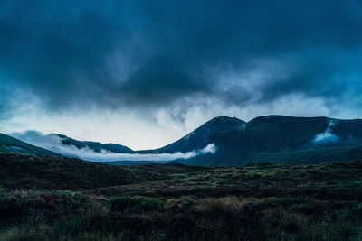 Scenic view of mountains against cloudy sky